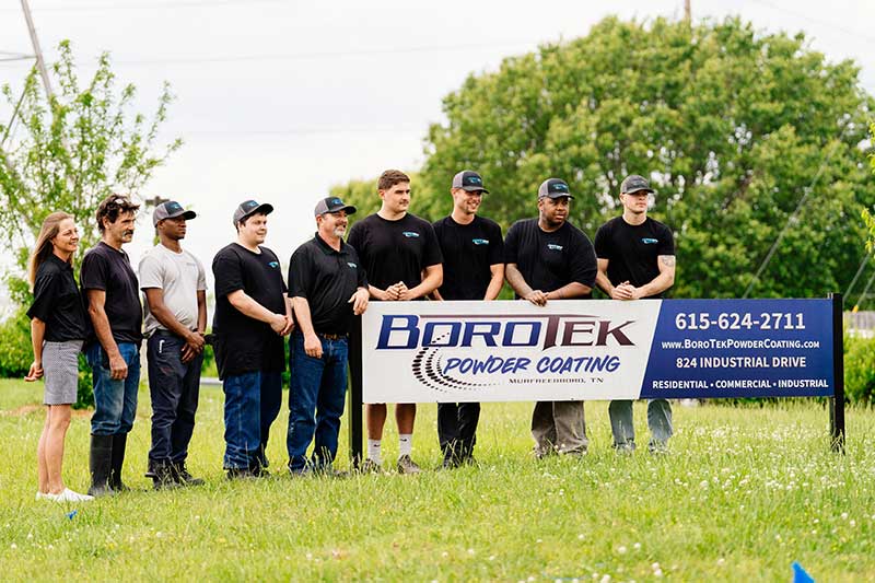 BoroTek Team photo standing behind BoroTek sign - Eight men and one lady.