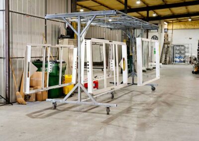 Large rectangular pieces of metal powder coated and hanging to dry.