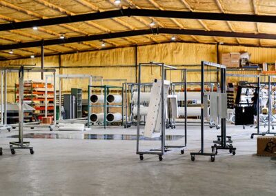 Wide view of warehouse with powder coated items hanging on racks.