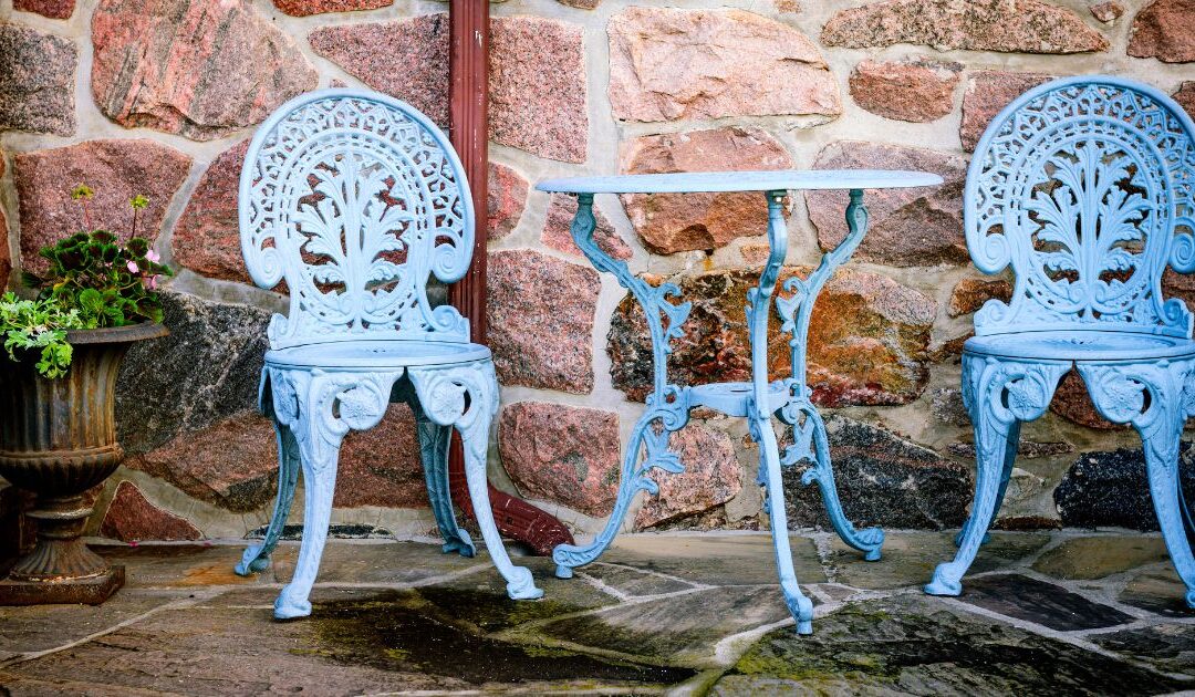 old-fashioned metal chairs that were painted light blue sitting against a brick wall